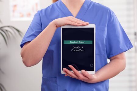 Adult female doctor or nurse show medical covid-19 corona virus report on tabletの写真素材