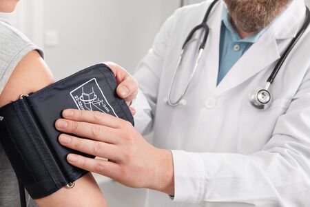 Doctor Checking Blood Pressure Of Patient In Hospitalの写真素材