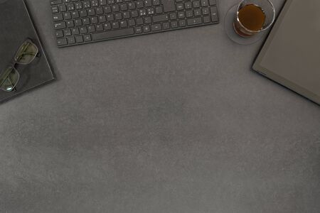 High angle view of contemporary black concrete office desk table with computer, supplies, notbook, tablet and coffee cup. Top view with copy spaceの写真素材