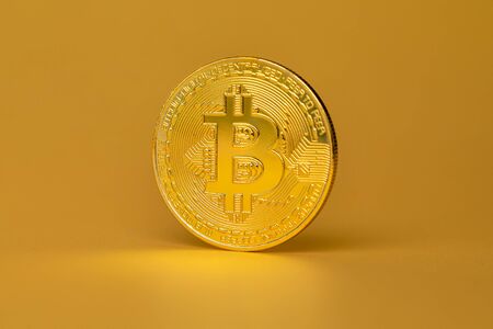 Bitcoin Crypto Currency Coin Standing On Golden Backgroundの写真素材