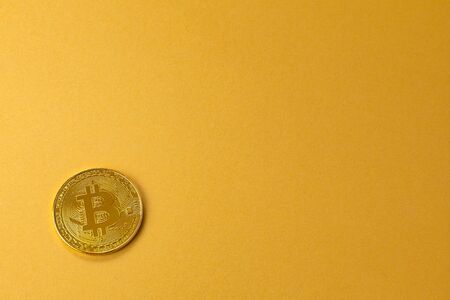 Gold bitcoin crypto currency coin on gold yellow backgoundの写真素材