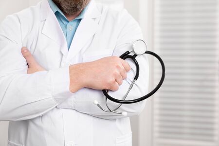 Close-up of a male doctor holding stethoscope in the officeの写真素材