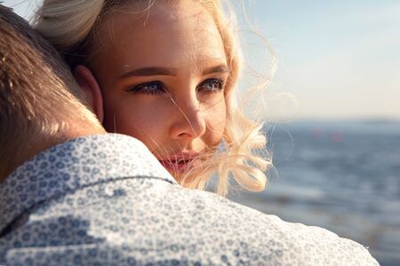 Portrait Of Young Woman Embracing Boyfriend At Beachの写真素材