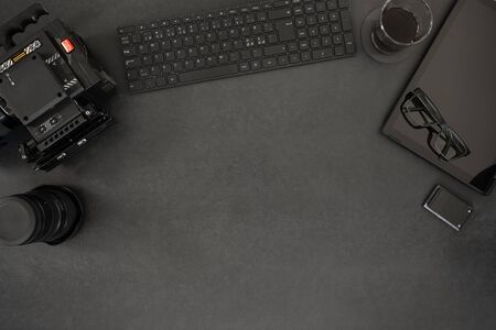Overhead view of computer keyboard and digital tablet with video camera. Directly above shot of coffee and electronic equipment. Blank space on black table.の写真素材