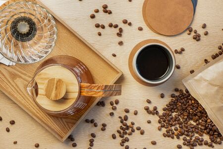 Directly above shot of fresh coffee with roasted beans on wooden tableの写真素材