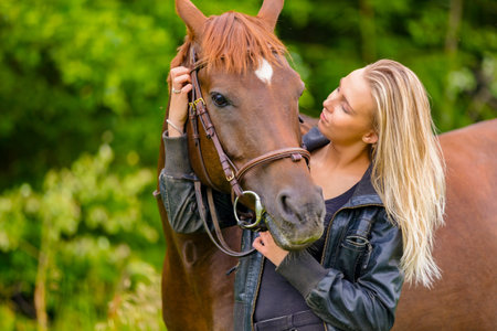Young woman with her arabian horse standing in the fieldの写真素材
