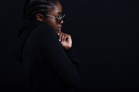 Posing african woman sitting with dark skin wearing round sunglassesの写真素材