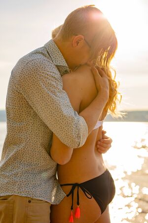 Caring man embrace beautiful girlfriend at the beachの写真素材