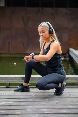 Beautiful fitness woman runner using smart watch phoneの写真素材