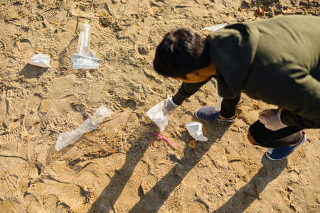 Top view of volunteer protecting environmental and picking up garbage at beachの写真素材