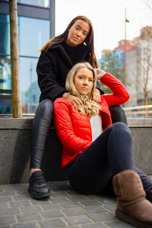 Portrait Of Two Best Friends Sitting Togehter In Cityの写真素材