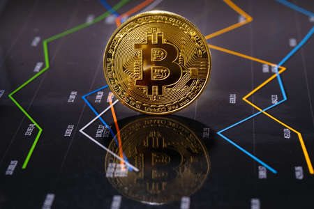 Closeup Of Gold Bitcoin Over Value Graphの写真素材