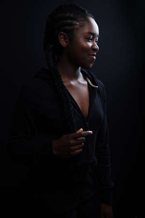 Cheerful and natural woman with dark skin wearing black hoodieの写真素材
