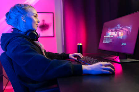 Professional gamer girl with headset play online multiplayer video game on PCの写真素材