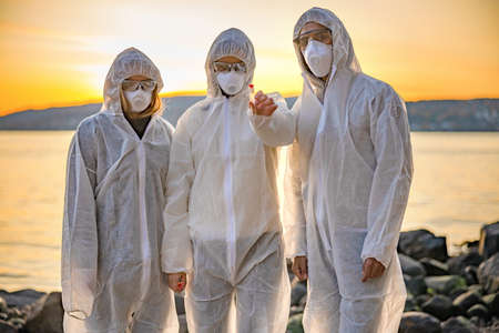 Dedicated team of scientists holding water sample at beachの写真素材