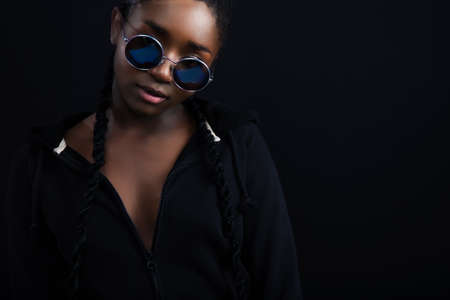 Confident african woman with dark skin wearing round sunglassesの写真素材