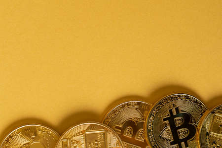 Gold Bitcoin Coins Lying On Golden Backgroundの写真素材
