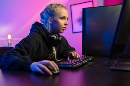 Focused Professional E-sport Gamer Girl Playing Online Video Game on PC