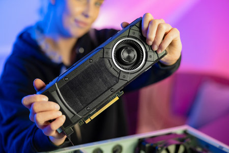 Gamer Girl Holding a New GPU Video Card in Her Handsの写真素材
