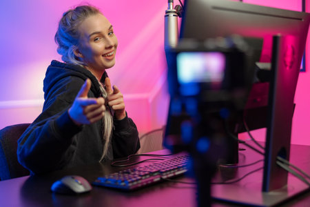 Funny and smiling e-sport gamer girl vlogging and plays online video game on PCの写真素材