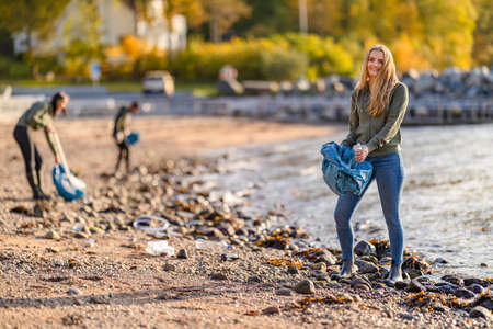 Dedicated volunteer team cleaning beach for plastic on sunny dayの写真素材