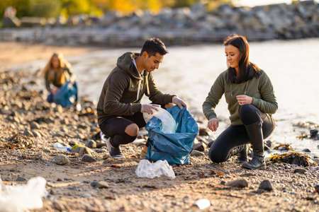 Team of hard working volunteers collecting plastic garbage at beachの写真素材