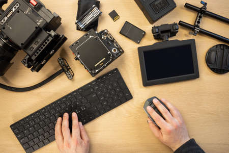 Creative photographer using computer parts by equipment at tableの写真素材