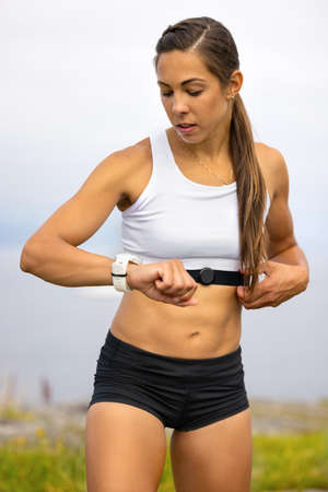 Portrait of woman using fitness smart watch device under workoutの写真素材