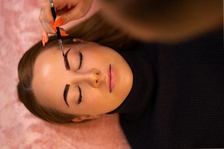 Cosmetologist Applying Dye On Female Customers Eyebrowの写真素材