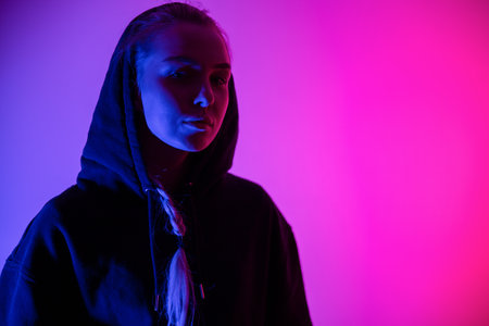 Colorful low-key portrait of a cool and confident blonde woman in hoodieの写真素材