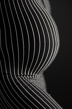 Curvy pregnant woman body in black and white striped pattern dress.の写真素材