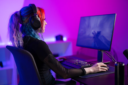 Focused Gamer Playing first-person shooter in a Vibrant, Colorful Roomの写真素材