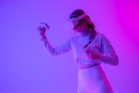 Young woman immersed in a vibrant virtual reality experience with neon lightsの写真素材