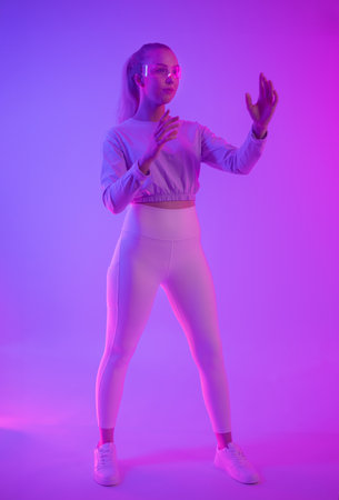Young woman explores virtual reality in dynamic neon lightingの写真素材