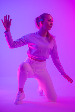 Woman interacting with virtual reality in vibrant neon colored lightingの写真素材