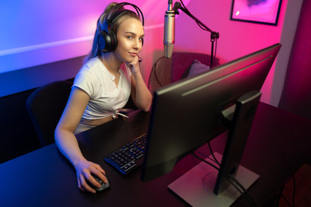 Happy Beautiful Blonde Gamer Girl Playing Online Video Game on Her Personal Computer.の写真素材