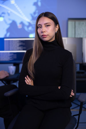 Portrait of a confident female Cybersecurity Analyst or Manager in large Cyber Security Operations Center SOC handling Threatsの写真素材