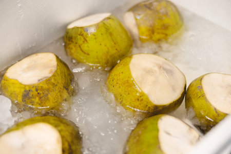 Fresh green coconuts on ice at a tropical street food marketの写真素材