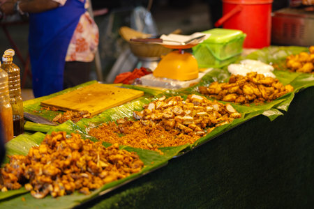 Authentic Thai street food displayed on banana leaves at a bustling marketの写真素材