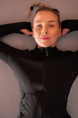 Confident Woman Relaxing in Activewear Looking Motivated and Contentの写真素材