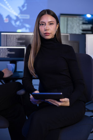 Serious Female Cybersecurity Analyst in large Cyber Security Operation Center SOC handling Threatsの写真素材