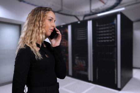 Woman on a phone call in data center with server racks behind
