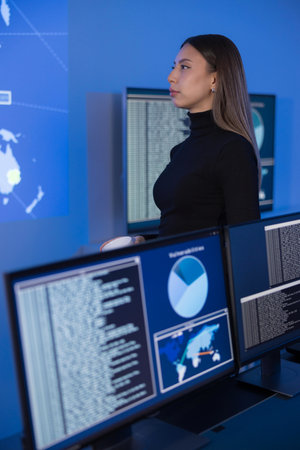 Cybersecurity analyst reviewing digital data dashboards for threat detection and analysisの写真素材
