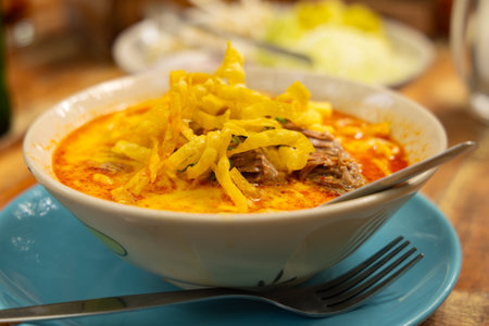 Delicious bowl of traditional Thai curry noodles with crispy toppingの写真素材