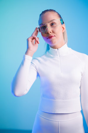 Woman using smartglasses against blue backgroundの写真素材