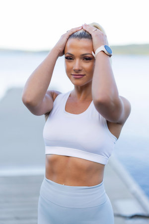 Woman Taking a Break During Outdoor Workout Wearing a Smartwatch and Activewearの写真素材