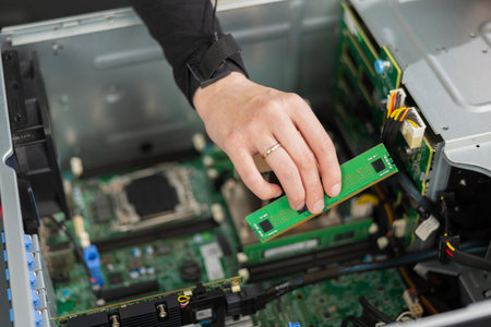 Adult male IT technician installs and upgrades server hardware inside a computer workstationの写真素材