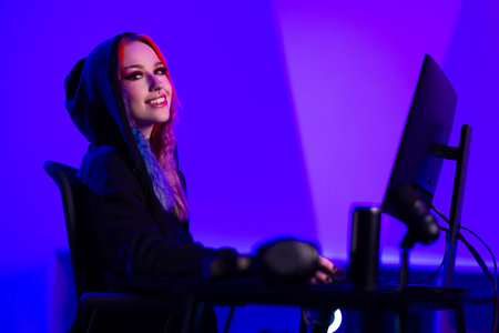 Young woman gaming at a stylish setup with vibrant purple lighting
