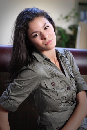 A pretty brunette, leaning back on a couch with her head tilted.の写真素材