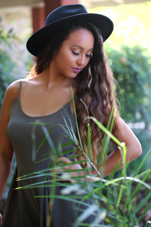 Girl in a hat in a gardenの写真素材